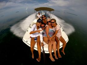 A lively group of friends enjoys a fun day on the water, capturing joyful moments aboard a speedboat. Perfect for celebrations and memorable outings.