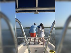 A family enjoys a scenic moment on the boat, capturing the beauty of the waterway together — perfect for memorable outings and bonding experiences.