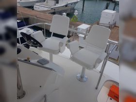 A clean and modern helm area featuring white seating and controls, ideal for navigating the waters in style and comfort.