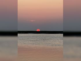 A serene sunset over calm waters, creating a picturesque backdrop for boating adventures.