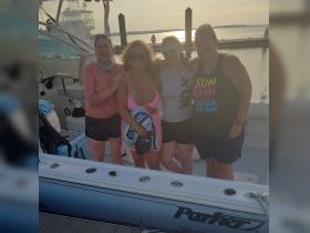 A cheerful group of friends poses on a boat at sunset, capturing a memorable moment of fun and camaraderie on the water.