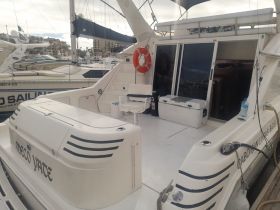 Interior view of a yacht showcasing the seating area and console, ideal for relaxing and enjoying the journey on the water.