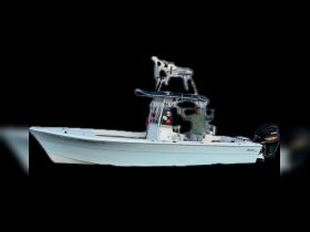 A fisherman proudly poses on a center console boat, showcasing the perfect setup for a day on the water.