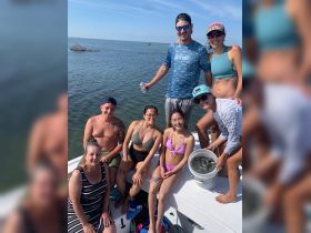 A lively group enjoys a fun day on the water, showcasing their catch while soaking up the sun on a boat. Perfect for family outings or fishing adventures.