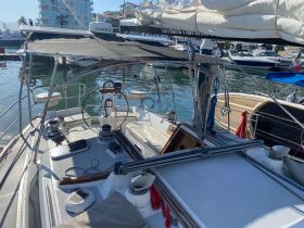 An interior view of a well-equipped sailboat helm, showcasing the steering console and seating area, perfect for navigating the open waters.