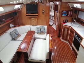 Interior view of a cozy boat cabin featuring comfortable seating and a well-equipped galley, perfect for relaxing during your nautical adventures.