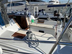 A well-appointed interior view of a sailboat, showcasing comfortable seating and helm area, perfect for relaxing during a day on the water.