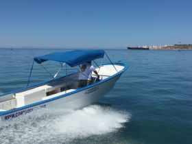 A speedboat navigates through calm waters, showcasing its sleek design and vibrant colors — perfect for thrilling adventures on the sea.