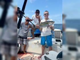 A group of anglers proudly displays their catch aboard a fishing boat, celebrating a successful day on the water. Perfect for fishing enthusiasts looking for adventure.