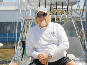 A man sits on a boat, possibly preparing for a fishing trip. The image captures a relaxed moment, but the focus is unclear.