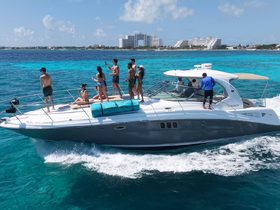 A lively group enjoys a day on the water aboard a sleek boat, capturing memories against a stunning turquoise backdrop — perfect for summer celebrations and adventures.