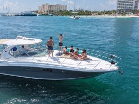 A lively group enjoys a fun day on a boat, celebrating with friends in the beautiful turquoise waters, perfect for summer outings and parties.