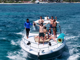 A lively group celebrates aboard a boat, enjoying the sun and water — perfect for unforgettable summer outings and party experiences.