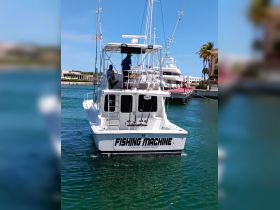 The 'Fishing Machine' boat is docked in Santo Domingo, showcasing its sleek design and fishing gear, perfect for deep-sea fishing adventures.