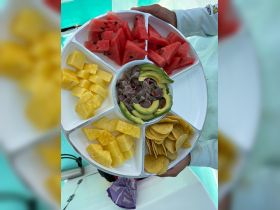 A vibrant platter of fresh fruit and snacks, perfect for enjoying on a boat trip. Ideal for catering or casual dining while out on the water.