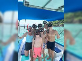 A cheerful group of snorkelers, including children, prepares for an underwater adventure on a boat — perfect for family outings and aquatic exploration.