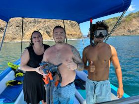 A cheerful group prepares for snorkeling on a boat, showcasing the excitement of ocean adventures and marine exploration.