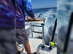 A person prepares a catch on a fishing boat, showcasing the excitement of ocean fishing adventures.