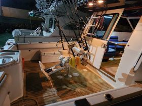 Interior view of a well-equipped boat cabin featuring seating and fishing gear, ideal for comfortable outings and fishing adventures.