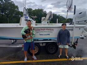 A joyful moment with a family by their fishing boat, featuring a dog and smiles all around — perfect for family fishing adventures and charters.