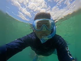A snorkeler captures a selfie underwater, showcasing the vibrant aquatic environment — perfect for adventure seekers and marine enthusiasts.