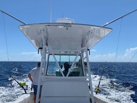 A group of anglers aboard a fishing boat, navigating the open ocean — perfect for deep-sea fishing adventures.
