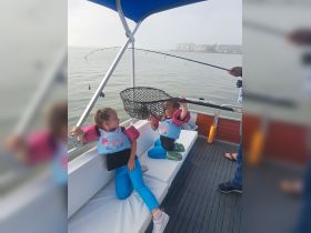 Two children enjoy a fun fishing experience on a boat, showcasing the joy of family outings on the water.