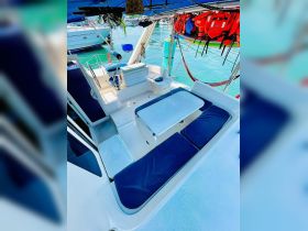 A well-appointed interior view of a boat's seating area, featuring comfortable cushions and a helm, perfect for relaxing while cruising.