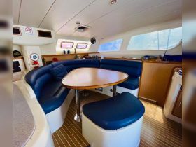 A cozy interior view of a boat's dining area featuring comfortable seating and a polished table, perfect for relaxing meals while on the water.