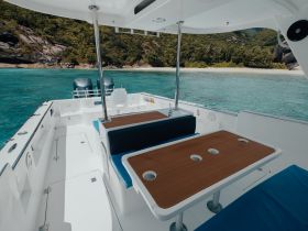 A spacious interior view of a boat featuring comfortable seating and a helm area, perfect for relaxing and enjoying the scenic surroundings.