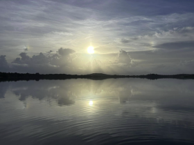 A serene view of a sunset reflecting on calm waters, creating a tranquil atmosphere perfect for relaxation.