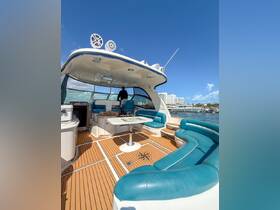 A spacious interior view of a luxury boat, showcasing comfortable seating and a helm area, perfect for relaxing or navigating the waters.