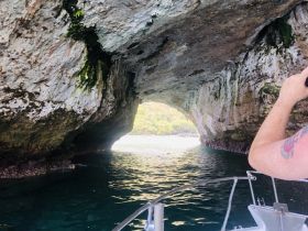 A captivating view from a boat as it navigates through a scenic cave, showcasing the stunning rock formations and tranquil waters — perfect for adventure seekers exploring hidden gems.