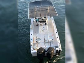 A top-down view of a center console fishing boat, showcasing its spacious layout and fishing gear, perfect for a day on the water.