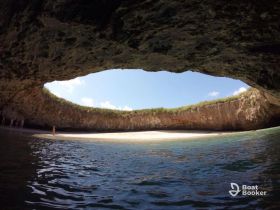 A stunning view of a beach inside a cave, with visitors enjoying the unique scenery — a perfect spot for exploration and adventure.