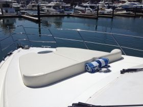 A serene view of the lounge area on a boat, featuring a comfortable seating pad and towels, perfect for relaxing on the water.