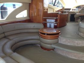 Interior view of a luxurious boat cabin featuring spacious seating and a well-equipped helm, perfect for relaxing and navigating on the water.