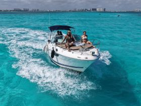 A lively group enjoys a day on the water aboard a boat, showcasing the vibrant turquoise sea and the excitement of a fun-filled trip.