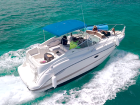 A group enjoys a sunny day on a boat cruising through clear turquoise waters, perfect for relaxation and adventure on the open sea.