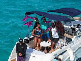 A lively group enjoys a fun moment aboard a boat, showcasing a vibrant atmosphere perfect for celebrations and water activities.