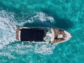 Aerial view of a couple enjoying their time on a yacht, surrounded by stunning turquoise waters — a perfect setting for a memorable boating experience.