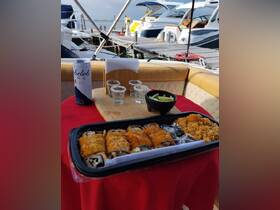 A delicious spread of sushi and drinks set up on a boat, perfect for enjoying a relaxing day on the water with friends or family.