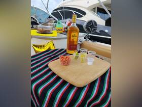 A vibrant display of snacks and cocktails on a boat, featuring tequila, lime, and colorful treats — perfect for a fun day on the water.