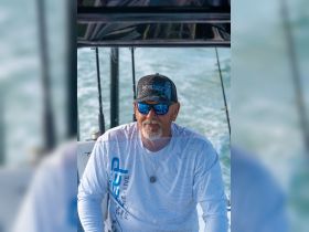 A man enjoys a day on the water, showcasing the relaxed lifestyle of boating and fishing. Perfect for those looking to embrace the boating culture.