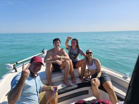 A cheerful group of friends enjoys a sunny day on the boat, capturing the essence of fun and relaxation on the water.