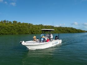 A group enjoys a day on the water aboard a boat, surrounded by lush greenery — perfect for fishing or exploring the beautiful waterways.