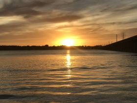 A stunning sunset over calm waters, reflecting golden hues — a perfect backdrop for evening boat trips or romantic getaways.