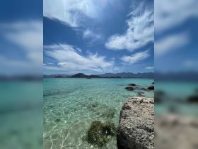 A stunning view of clear turquoise waters and rocky coastline, showcasing the beauty of a tropical destination — perfect for island hopping and beach adventures.