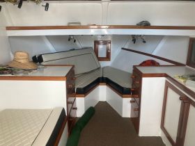 Interior view of a boat cabin featuring comfortable seating and storage, ideal for relaxing during trips on the water.