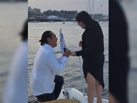A romantic proposal unfolds on a boat at sunset, capturing a special moment between a couple — perfect for unforgettable engagements on the water.